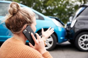 Woman talking on cell phone explaining car crash