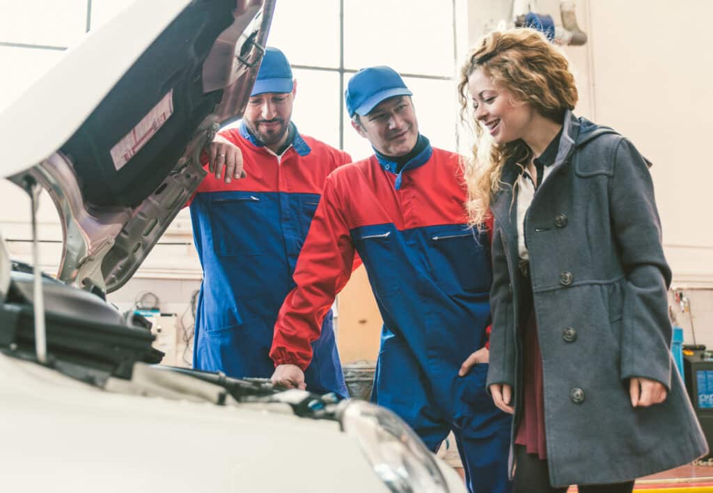 Mechanic and customer talking about fixing solutions in a collision repair shop