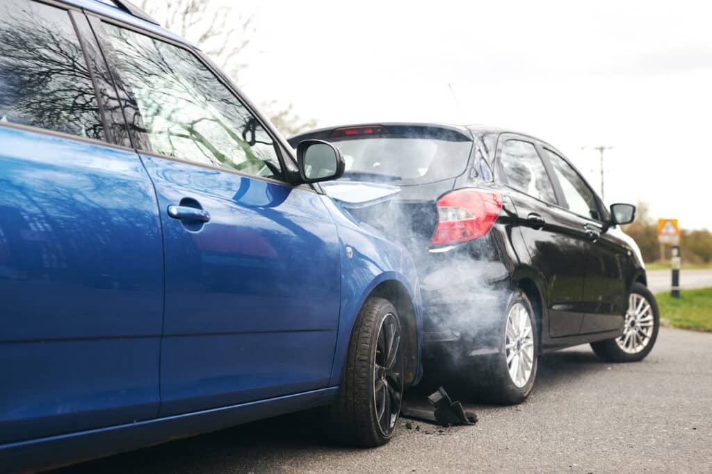 Two Damaged Cars Involved In Road Traffic Accident Showing Smoke After Collision