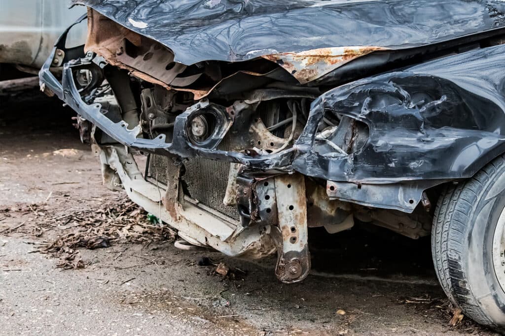 Vehicle with missing front bumper and crushed hood in need of car damage repair