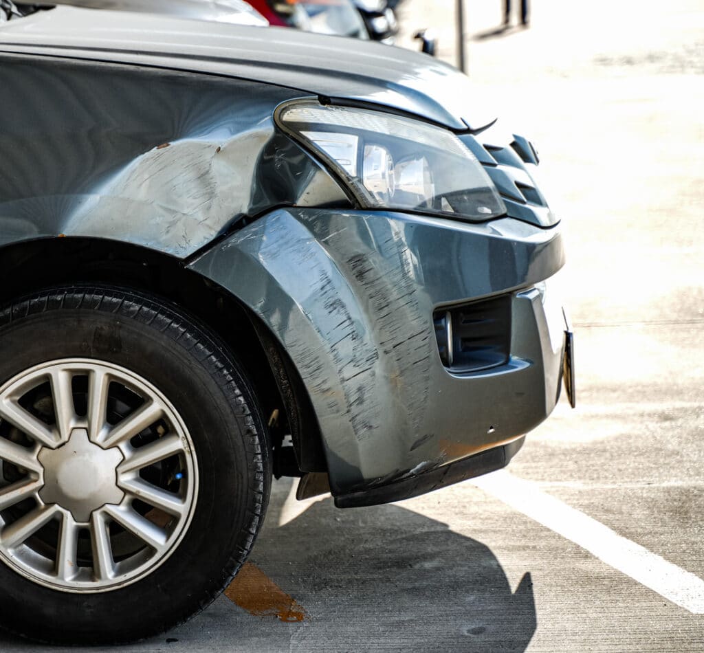 A car with a dent by the headlight