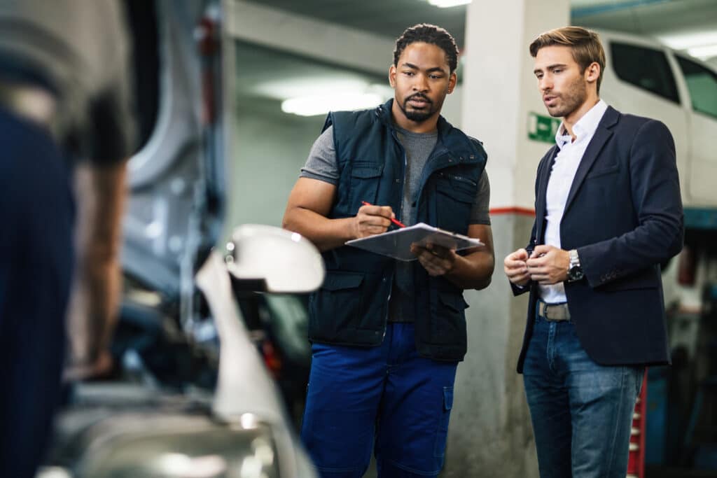 A man talking with a mechanic about his auto repair estimate