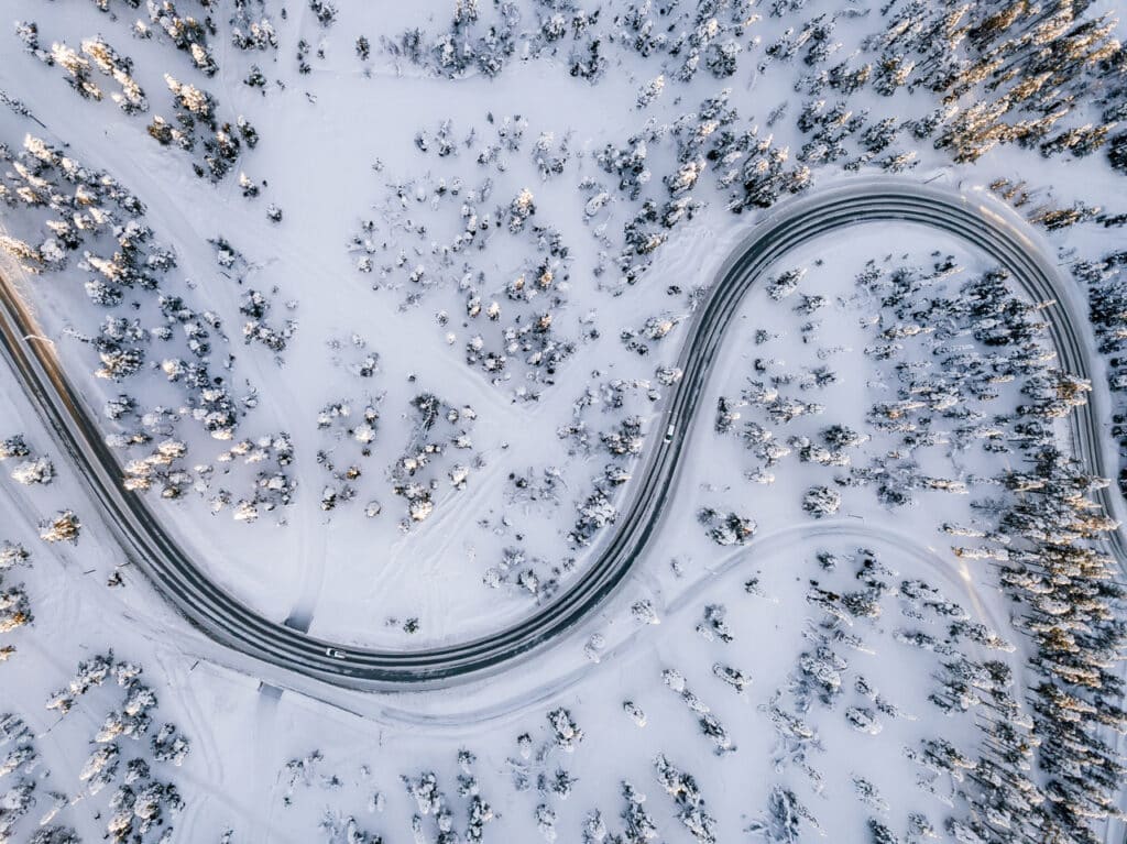 Aerial view of a curvy, icy road in snow