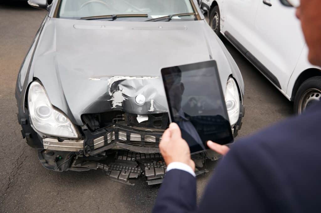 man looking at hit and run car damage